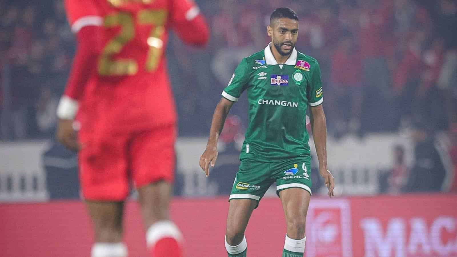 لاعب كرة قدم مغربي في الملعب خلال المباراة، يعرض أخبار الرياضة في المغرب.