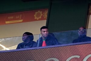 Jeune homme regardant un match de sport dans une loge VIP au stade du Maroc.