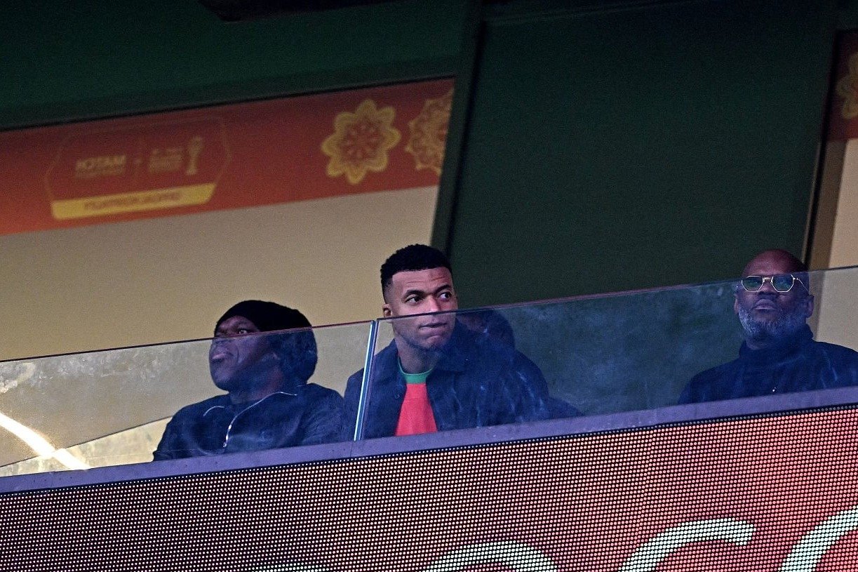 Jeune homme regardant un match de sport dans une loge VIP au stade du Maroc.
