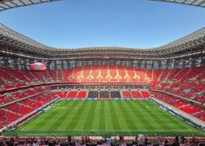Stade au Maroc avec des sièges rouges et une architecture moderne, accueillant des matchs de football et des événements.