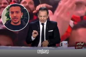 Présentateur de nouvelles marocain à la télévision en direct avec le public en arrière-plan, couverture médiatique, diffusion télévisée marocaine.