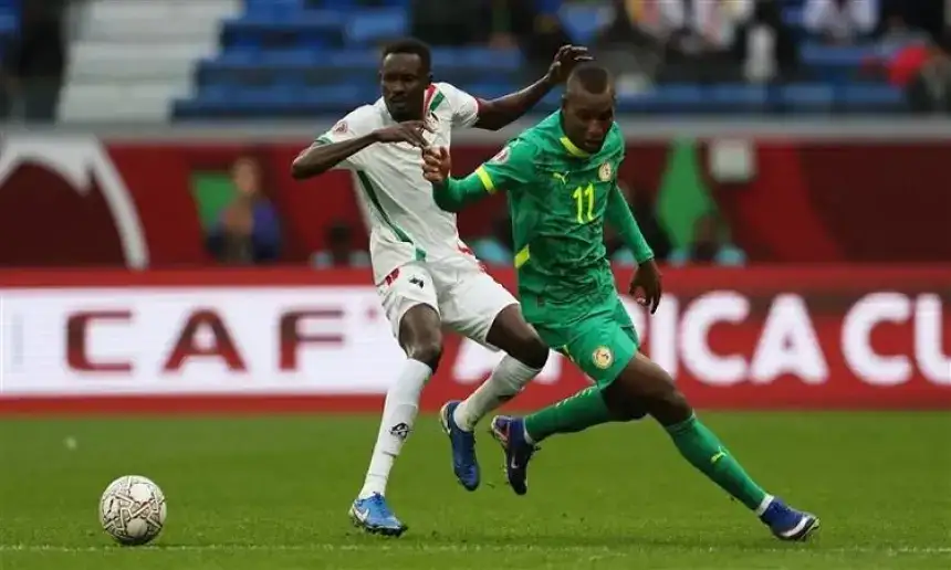 Moroccan player challenges a Senegalese opponent during a pivotal moment in the CAF Africa Cup match, showcasing intense competition.