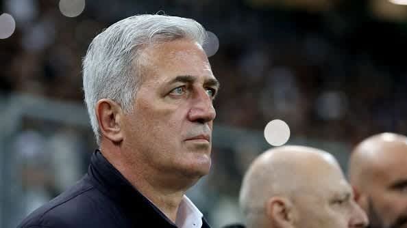 Vladimir Petković, concentré et contemplatif, observe le match, avec un arrière-plan flou de spectateurs et de membres du staff.