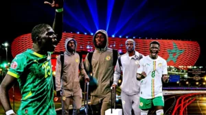 Senegalese football players celebrate with the Moroccan stadium backdrop illuminated in red and green, showcasing national pride ahead of a match.