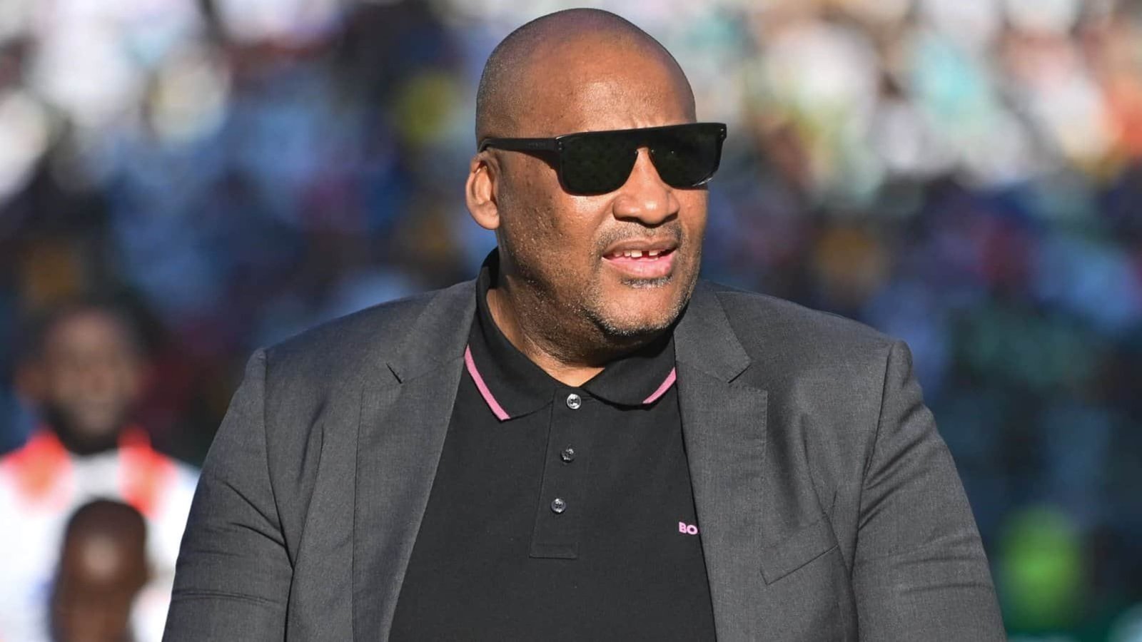 Événement d'actualité marocain mettant en vedette un homme en lunettes de soleil élégantes et en tenue formelle.