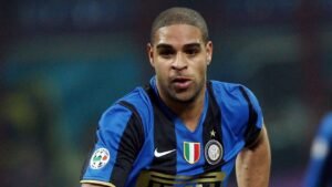 Adriano, gekleed in een Inter Milan-tenue met blauw-zwarte strepen, focust intens op de wedstrijd en toont zijn vastberadenheid.