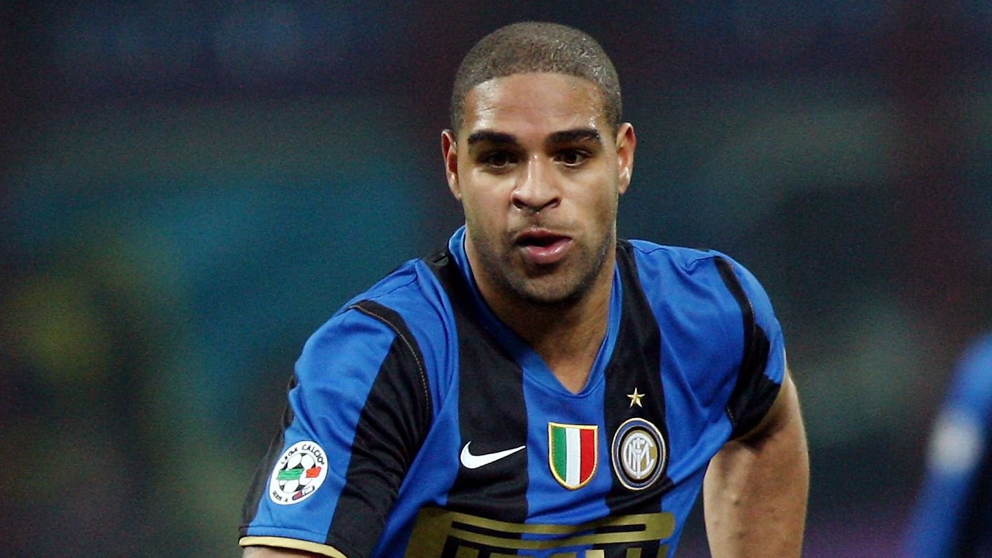 Adriano, gekleed in een Inter Milan-tenue met blauw-zwarte strepen, focust intens op de wedstrijd en toont zijn vastberadenheid.
