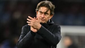 Brentford-manager Thomas Frank applaudisseert voor het publiek, gekleed in een zwart jasje, met een serieuze uitdrukking na een wedstrijd.
