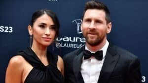 Lionel Messi en Antonela Roccuzzo poseren samen op de Laureus Awards, beiden elegant gekleed tegen een donkerblauwe achtergrond.