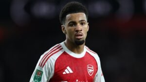 Ethan Nwaneri in het rood-witte tenue van Arsenal, geconcentreerd op het veld tijdens een wedstrijd, met een zichtbaar Carabao Cup-embleem.