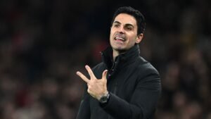 Mikel Arteta gebaart gepassioneerd aan de zijlijn tijdens een Premier League-wedstrijd, gekleed in een zwarte jas, wat zijn leiderschap voor Arsenal toont.