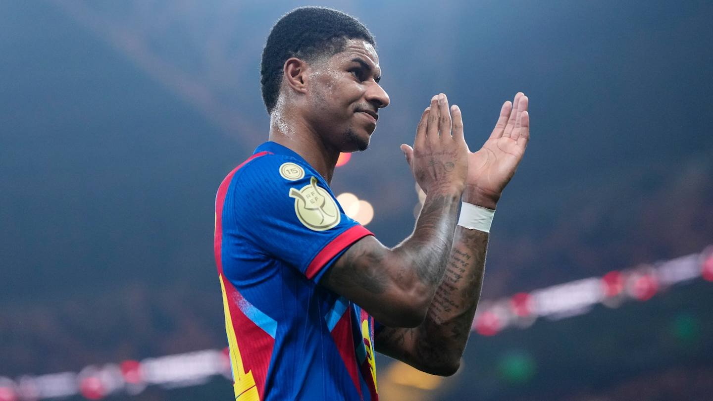 Marcus Rashford de Barcelone salue les supporters, portant le maillot bleu et rouge vif de l'équipe, dans une atmosphère de stade animée.