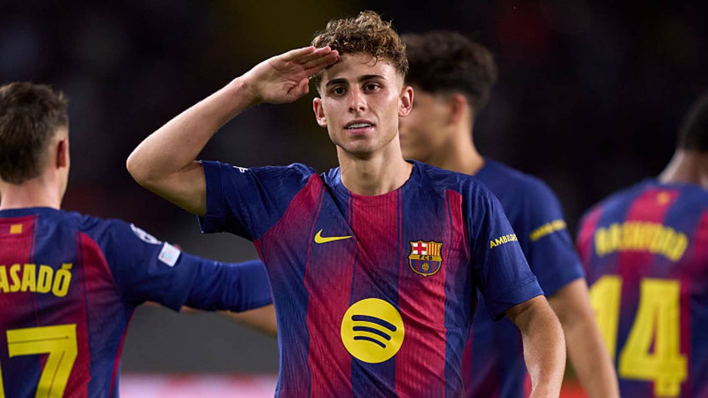 لاعب برشلونة يحيي الجماهير خلال مباراة وهو يرتدي الزي الأيقوني للأزرق القرمزي، مما يبرز موهبة لا ماسيا.