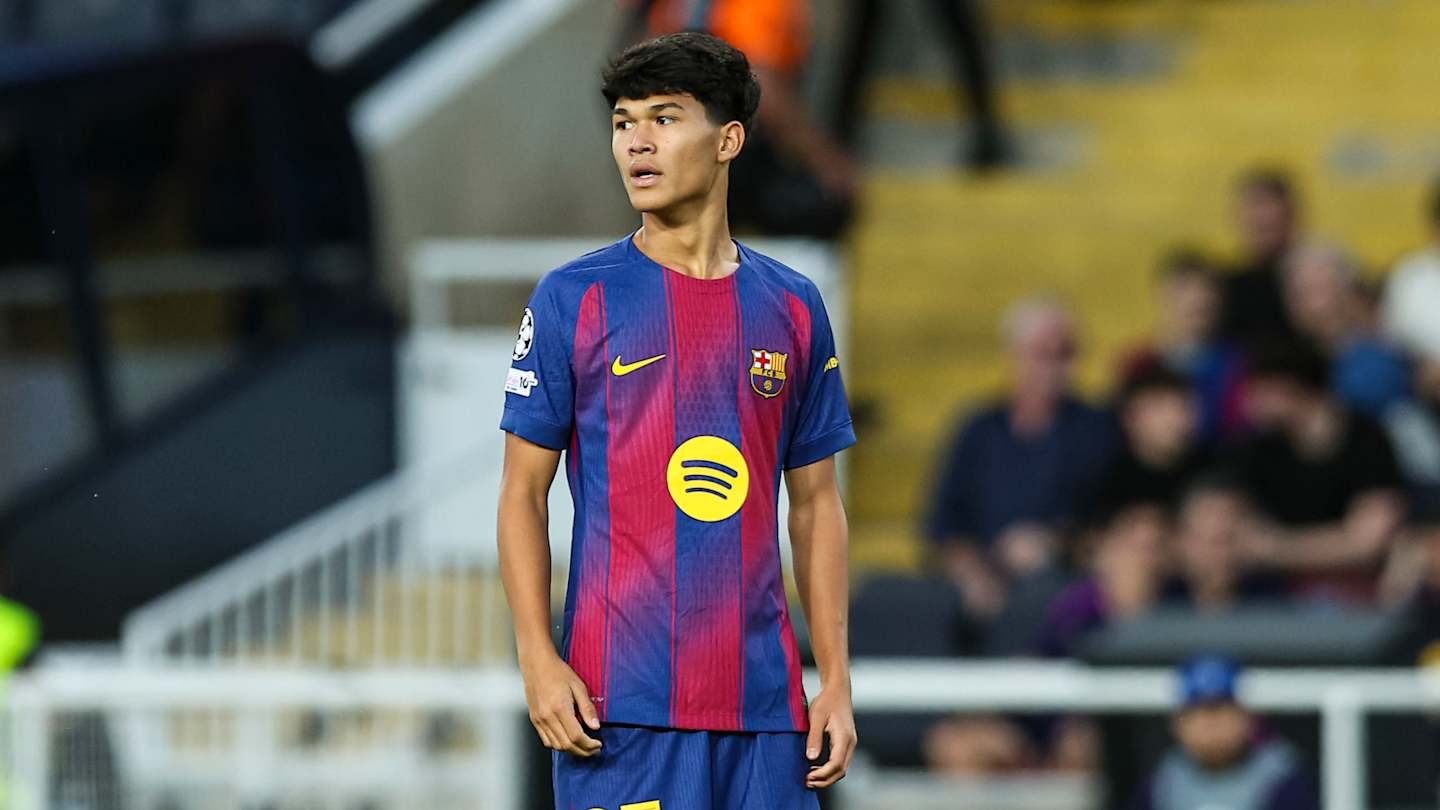 La pépite du Barcelone, Dro Fernandez, se tient sur le terrain dans un maillot marron et bleu vibrant, observant l'action du match au milieu d'une foule passionnée.