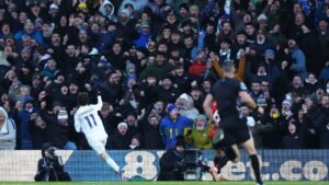 Brenden Aaronson célèbre son but pour Leeds United tandis que des supporters en extase l'acclament en arrière-plan lors du match de Premier League contre Manchester United.