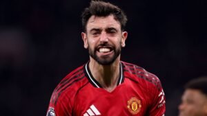 Bruno Fernandes célèbre avec passion dans le maillot rouge de Manchester United, faisant preuve d'une intense émotion sur le terrain pendant un match.