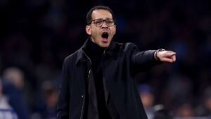 Moroccan football manager passionately directing players from the sidelines during a crucial match, emphasising strategy and intensity.