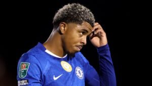 Chelsea's Wesley Fofana ziet er bezorgd uit tijdens een wedstrijd, gekleed in het blauwe tenue van de ploeg met zichtbare clubemblemen, wat zijn recente moeilijkheden weerspiegelt.