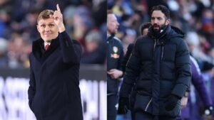 Darren Fletcher gebaart positief aan de linkerkant, terwijl een geconcentreerde trainer in een zwarte jas aan de rechterkant loopt, tegen de achtergrond van een voetbalwedstrijd.