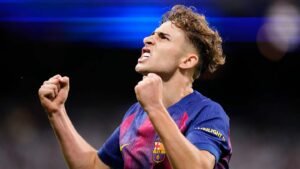Barcelona player celebrates passionately with clenched fist, wearing the club's vibrant blue and claret kit, during a match.