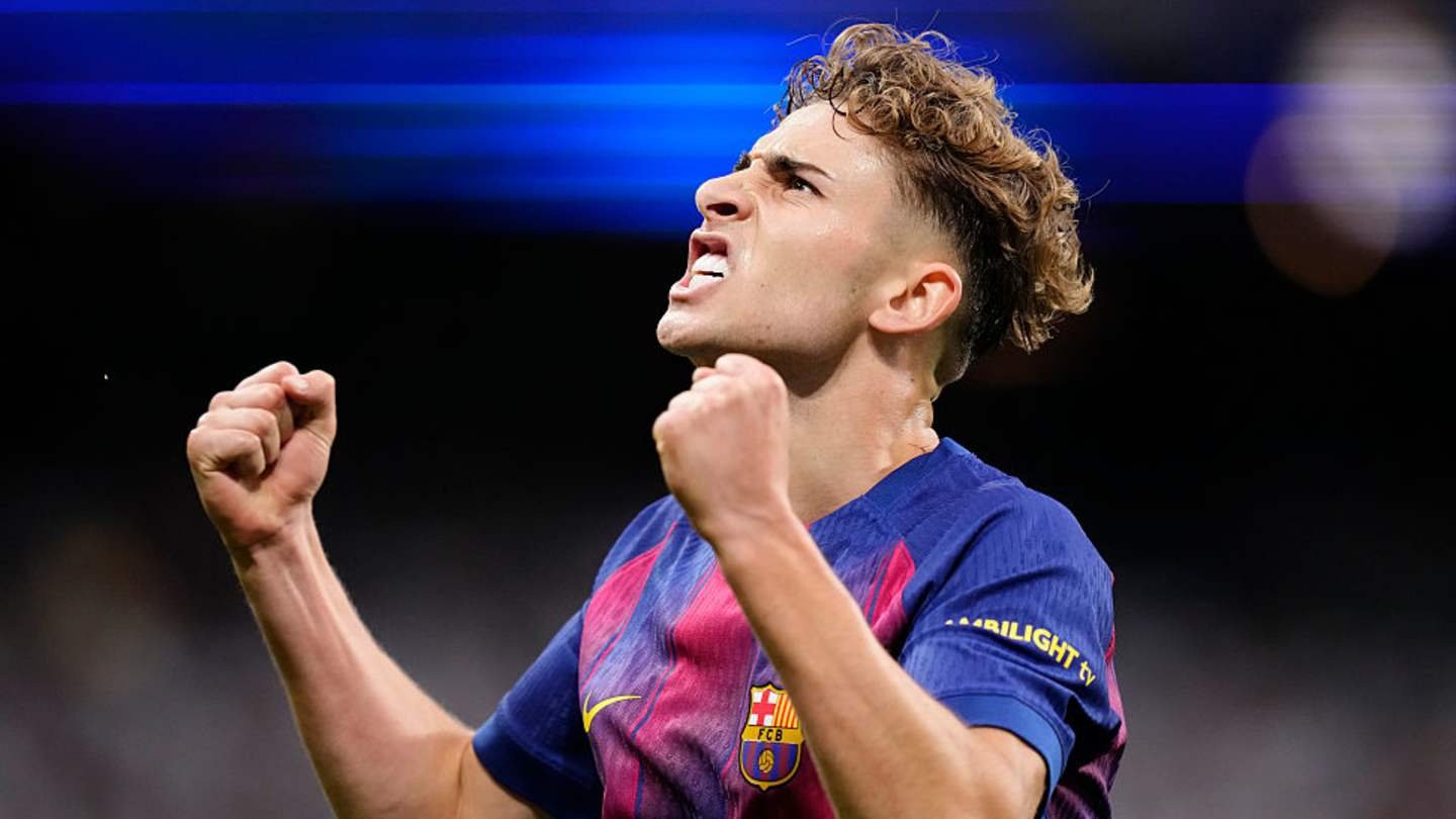 Barcelona player celebrates passionately with clenched fist, wearing the club's vibrant blue and claret kit, during a match.