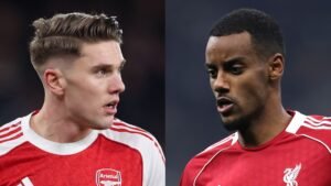 Arsenal's speler in rood kijkt naar links en Liverpool's speler in rood kijkt naar rechts, beiden met intense uitdrukkingen tijdens een wedstrijd.