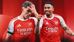Arsenal-spelers in rode tenues, de ene toont frustratie en de andere viert, tegen een levendige rode achtergrond, wat het teamgeest symboliseert.