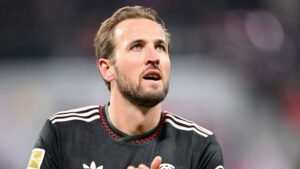 Harry Kane lève les yeux en portant le maillot noir du Bayern Munich rehaussé de rouge, réfléchissant au match suite à la victoire sur Leipzig.