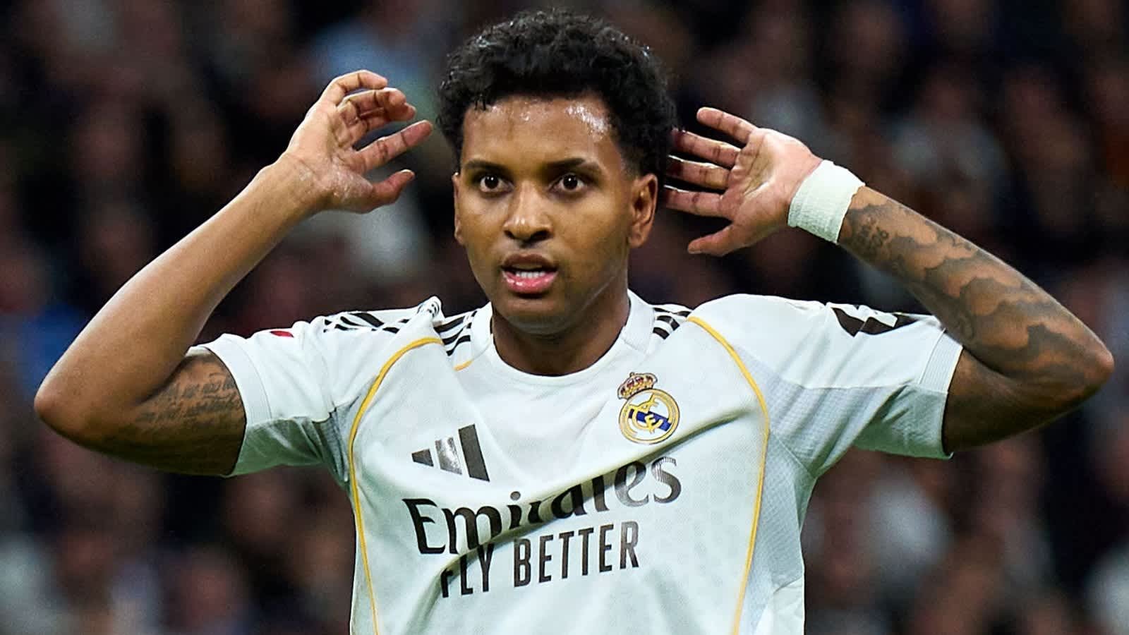 رودريغو يحتفل بتسجيل هدف لريال مدريد، مرتديًا قميص النادي الأبيض مع لمسات ذهبية، في أجواء ملعب نابضة بالحياة.