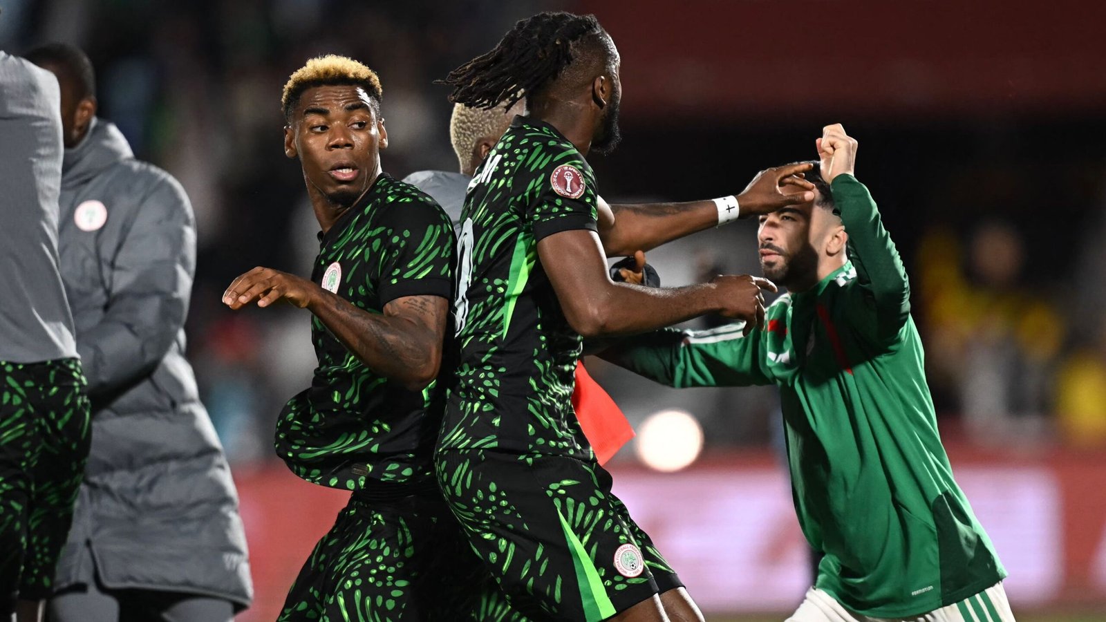 Nigeriaanse spelers in levendige groene tenues confronteren een Marokkaanse speler in het groen, tijdens een gespannen moment in de AFCON-kwartfinales.