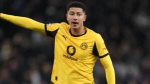 Jobe Bellingham in zijn gele Borussia Dortmund-tenue, gebarend tijdens een wedstrijd, toont concentratie en betrokkenheid op het veld.