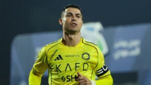 Cristiano Ronaldo, portant le maillot jaune vif d'Al Nassr, affiche concentration et détermination lors d'un match de la Saudi Pro League.
