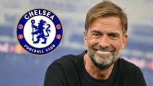 Jürgen Klopp sourit avec assurance, devant le logo du Chelsea FC, soulignant l'intérêt managérial potentiel pour le club.