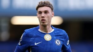 ليام روزينور يرتدي زي تشيلسي الأزرق مع شارة بطولة العالم للفيفا، يبدو مركزاً على الملعب خلال مباراة.