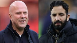 Deux entraîneurs de football, l'un chauve et souriant, l'autre barbu, tous deux en vestes sombres, se détachant sur un fond de stade flou.