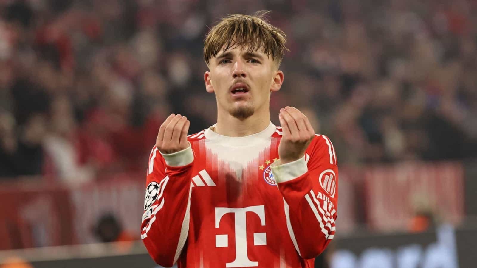 Le jeune joueur du Bayern Munich fait un geste des deux mains dans un moment d'émotion pendant un match, portant le maillot emblématique rouge et blanc de l'équipe.