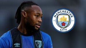 Antoine Semenyo en tenue d'AFC Bournemouth, envisageant un transfert vers Manchester City, le logo de ce dernier étant clairement visible en arrière-plan.