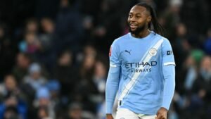 Man City-speler viert tijdens de FA Cup-wedstrijd, gekleed in de luchtblauwe outfit van het team, temidden van een opgewonden menigte op de achtergrond.