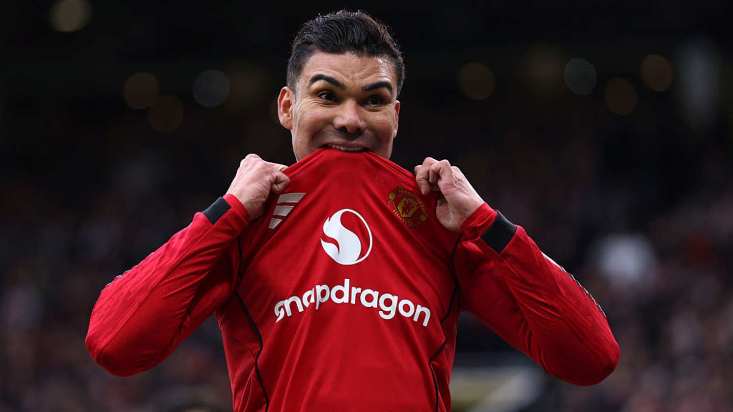 كاسيميرو يسحب قميص مانشستر يونايتد بفرح، معرضًا الزي الأحمر وشعار النادي خلال احتفال في مباراة.