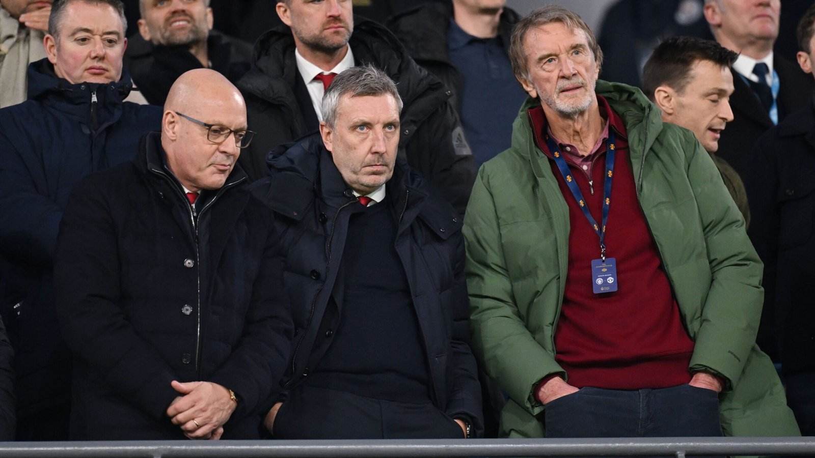 Manchester United-directeur Jason Wilcox onder de fans, met uitdrukkingen van bezorgdheid of ongenoegen op Old Trafford tijdens een gespannen wedstrijdsfeer.