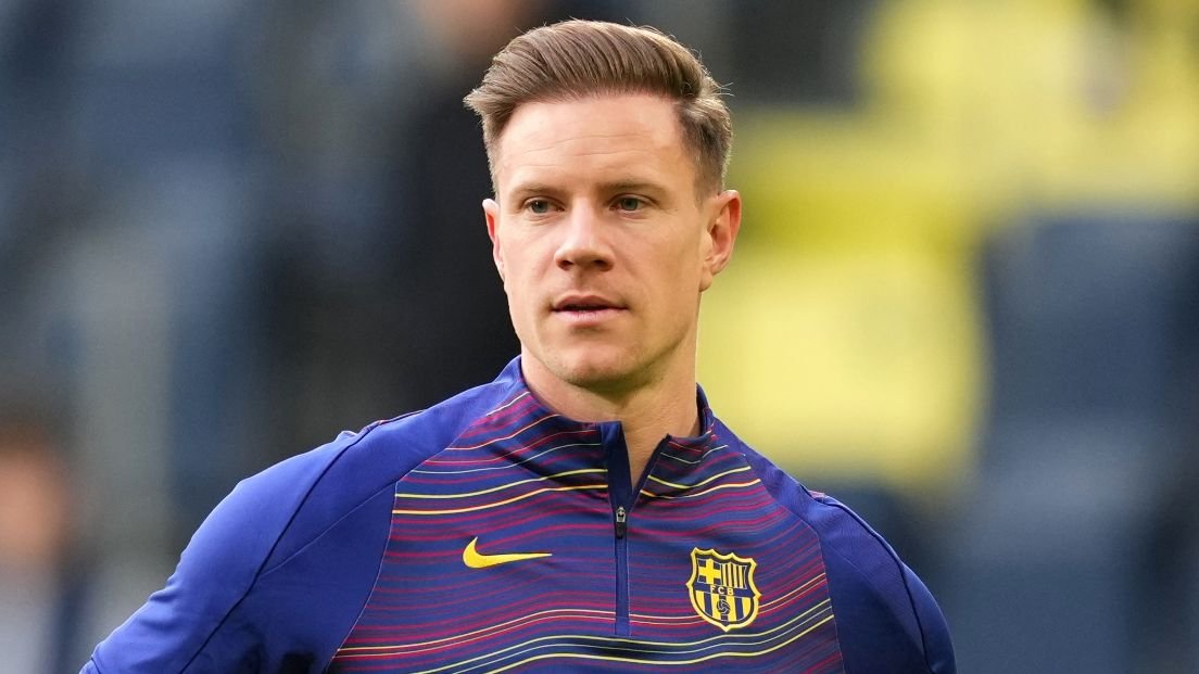 Marc-André ter Stegen dans un haut d'entraînement du Barcelone au design vibrant, l'expression concentrée, se préparant pour un match.