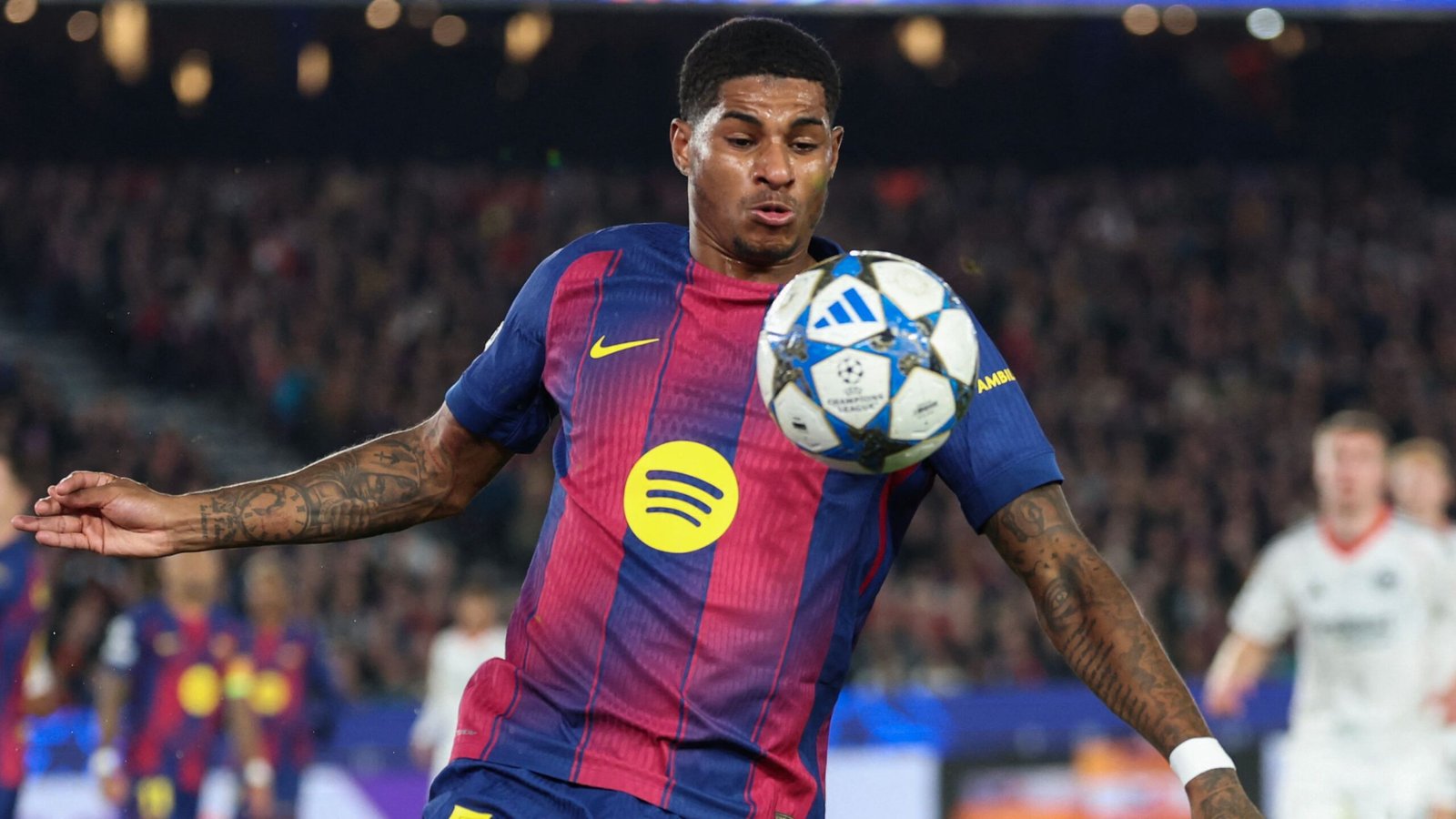 Marcus Rashford controleert behendig de bal in het levendige blauw en kastanjebruin tenue van Barcelona tijdens een Champions League-wedstrijd.