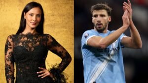 Maya Jama poseert in een adembenemende zwarte kantjurk tegen een gouden achtergrond, terwijl Ruben Dias klapt in een lichtblauw Manchester City-tenue.
