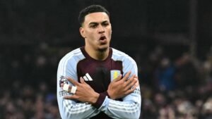 Morgan Rogers portant le maillot grenat et bleu d'Aston Villa, exprimant avec passion ses émotions pendant un match, le visage concentré.