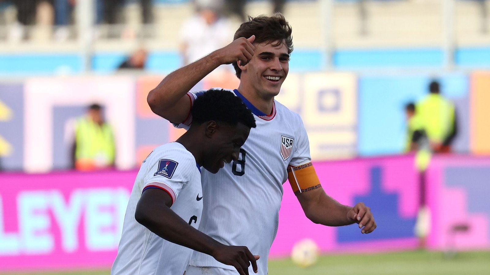 Benjamin Cremaschi viert met een teamgenoot na het winnen van een U.S. Soccer-prijs, gekleed in een USA-tenue met een vrolijke uitdrukking en opgestoken duim.