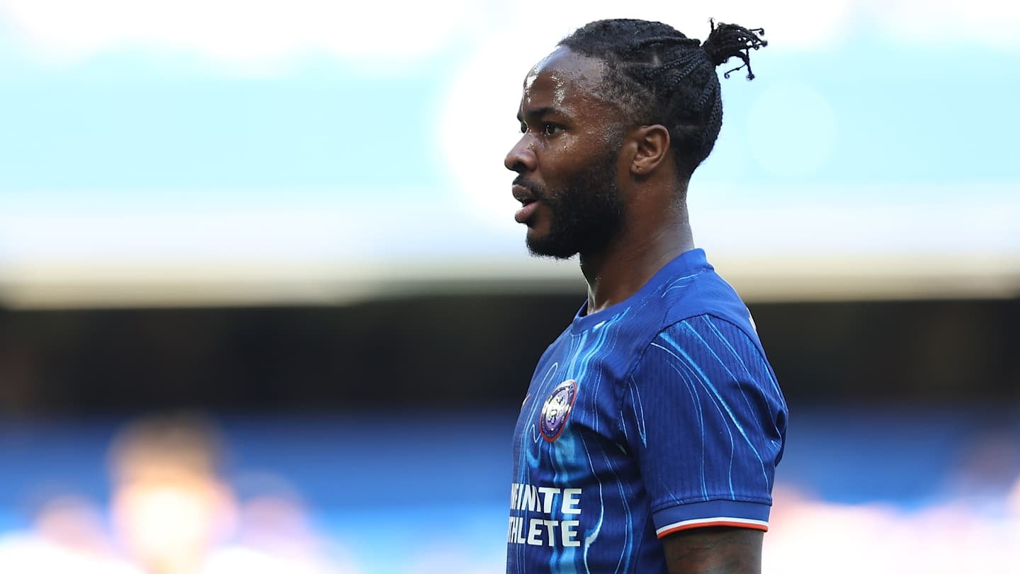 Raheem Sterling in a blue Chelsea kit, focused during a match, showcasing his determination on the pitch.
