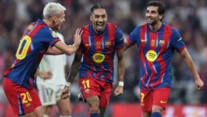 Raphinha célèbre avec ses coéquipiers après avoir marqué lors de la victoire du Barcelone sur le Real Madrid en Supercoupe d'Espagne, mettant en valeur les couleurs vives de l'équipe.