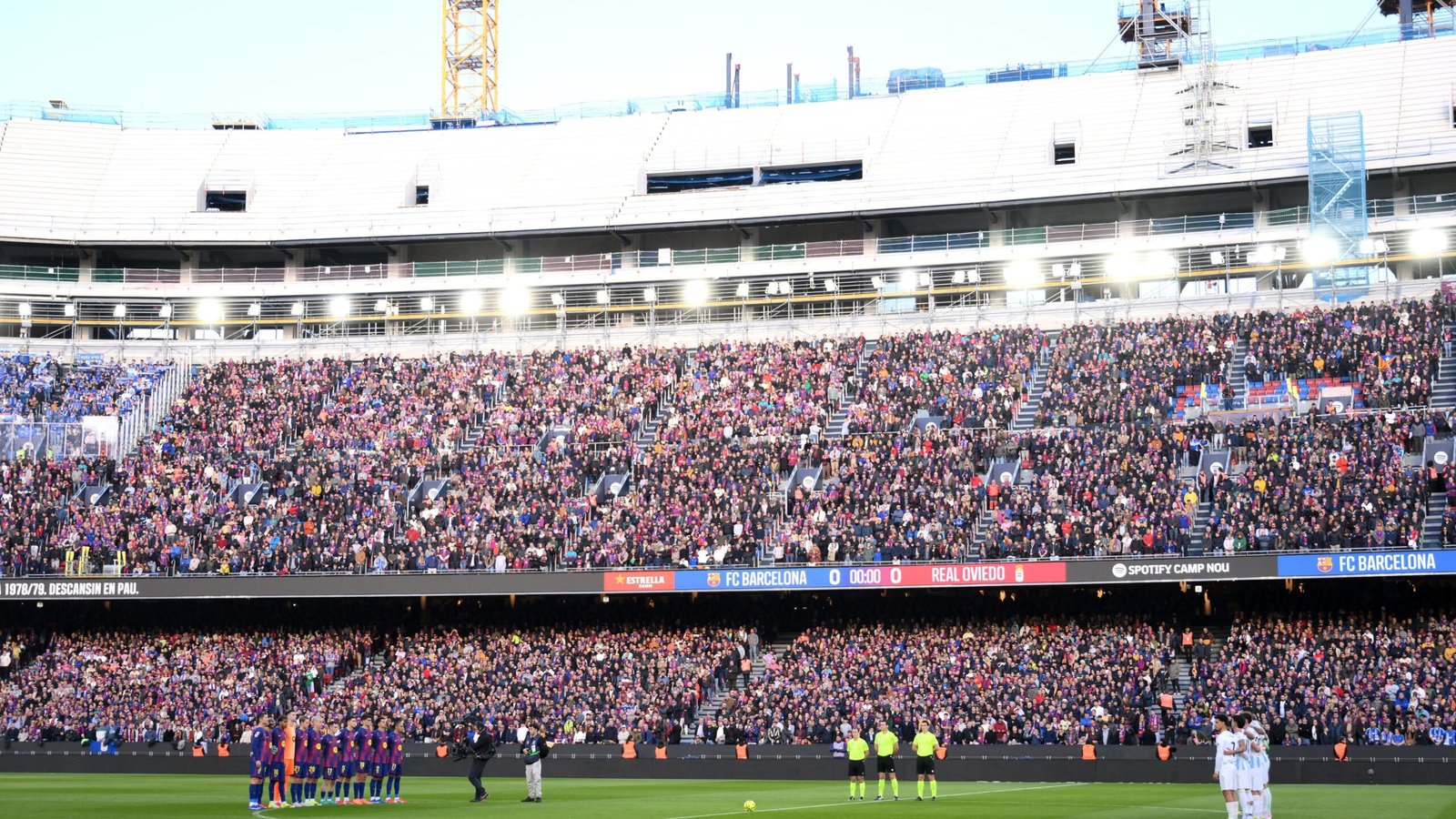 De spelers van Barcelona staan opgesteld op het veld van een uitverkocht Camp Nou, met fans in levendige kleuren, wanneer FC Barcelona het opneemt tegen Real Oviedo.