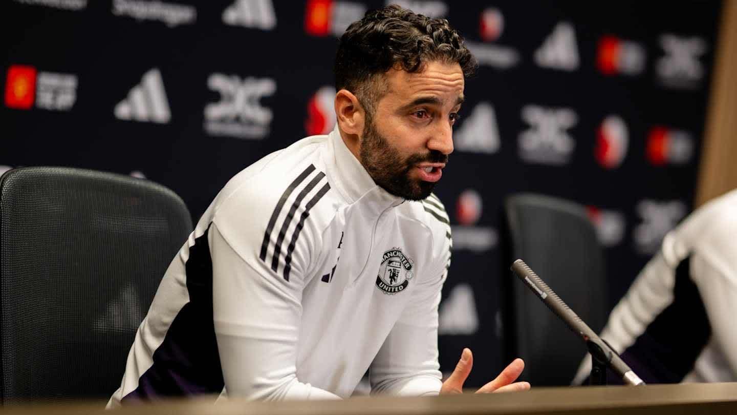 Rubén Amorim, vêtu d'un survêtement de Manchester United, s'exprime avec passion lors d'une conférence de presse, discutant des stratégies de transfert.