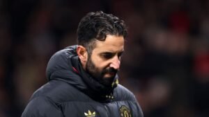 Ruben Amorim semble déçu, vêtu d'une sombre veste de Manchester United, exprimant un sentiment de trahison suite à son licenciement.